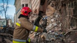 Украинский пожарный работает возле разрушенного жилого дома в Харькове