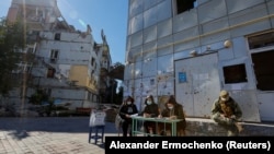 Члены так называемой избирательной комиссии возле разрушенного жилого дома на третий день псевдореферендума о присоединении так называемой "ДНР" к России. Мариуполь, Украина, 25 сентября 2022 года