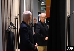 Лауреат Нобелевской премии мира 2022 года Алесь Беляцкий в сопровождении жены Натальи Пинчук примеряет новый костюм в торговом центре в Вильнюсе, 14 декабря 2025 года, на следующий день после освобождения из тюрьмы. Фото AFP