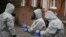 U.K. -- Military personnel wearing protective coveralls work to remove vehicles from a cordoned off area behind a police station in Salisbury, March 11, 2018