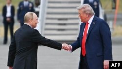 Президент США Дональд Трамп приветствует Владимира Путина на взлетно-посадочной в Анкоридже, Аляска, 15 августа 2025 года