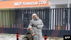 Родственники убитого мальчика на фоне школы 