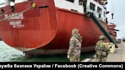 Сотрудники СБУ на фоне арестованного судна